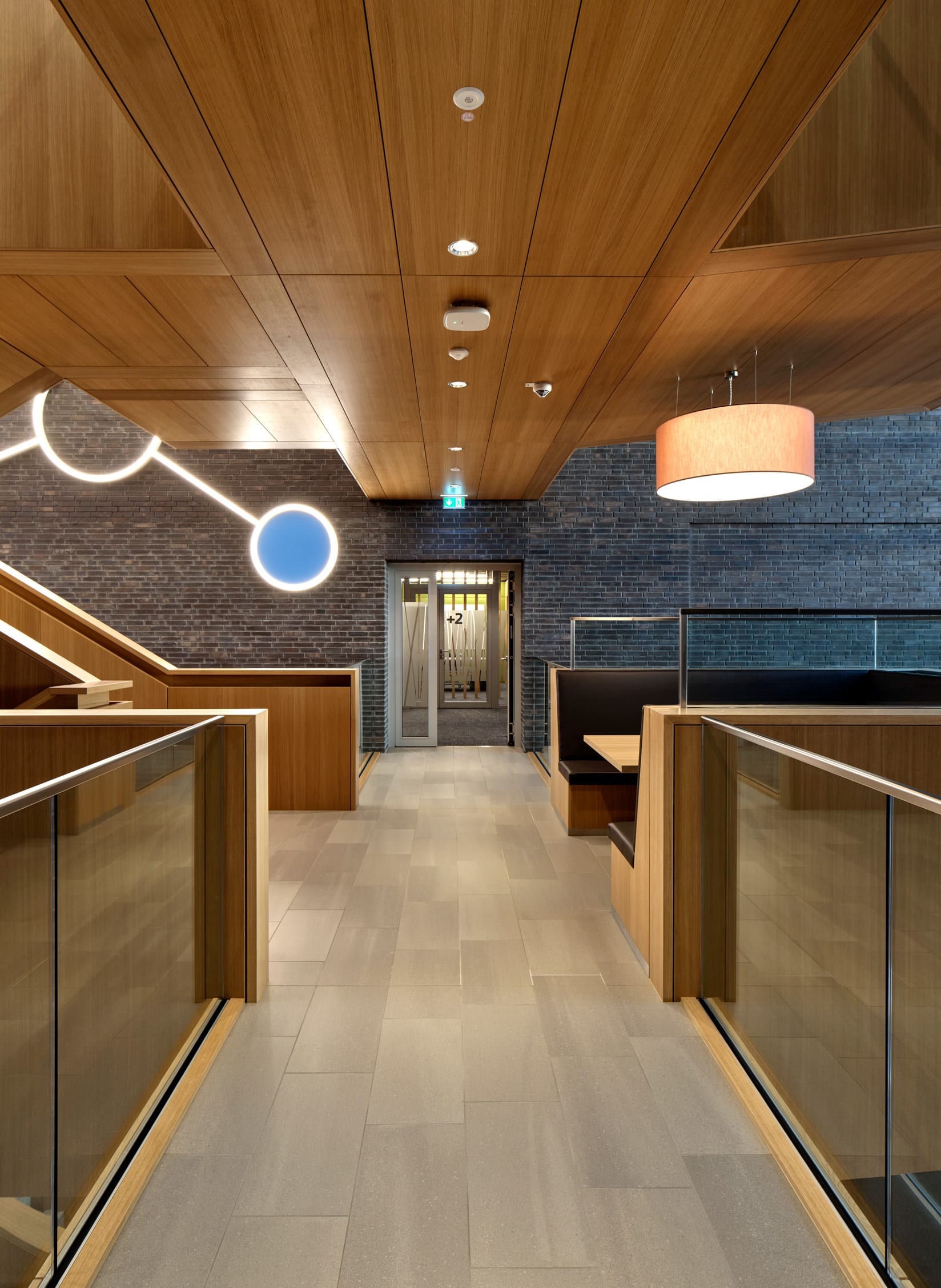 Wand- und Deckenverkleidung aus Eichenholz in einem modernen Treppenhaus oder Flur – warme Holzoberflächen schaffen eine einladende und hochwertige Atmosphäre.