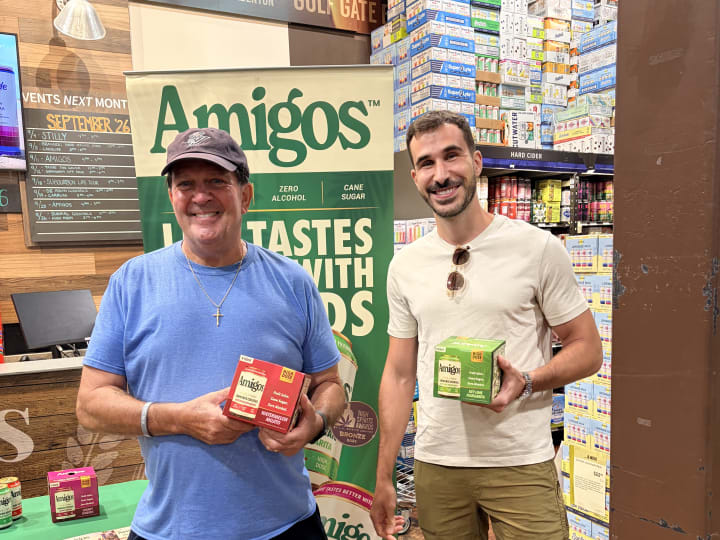 Amigos activation with the branded banner, ambassador and shoppers holding product