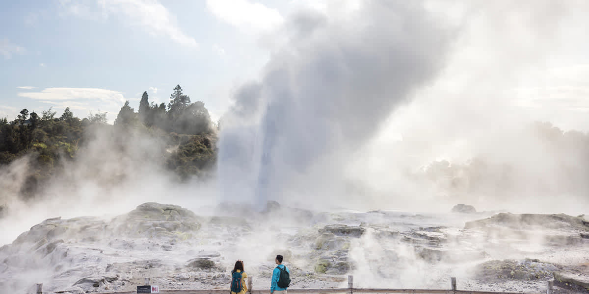 Guests watching geothermal geysers near Rotorua on the North Island Volcanic Adventure