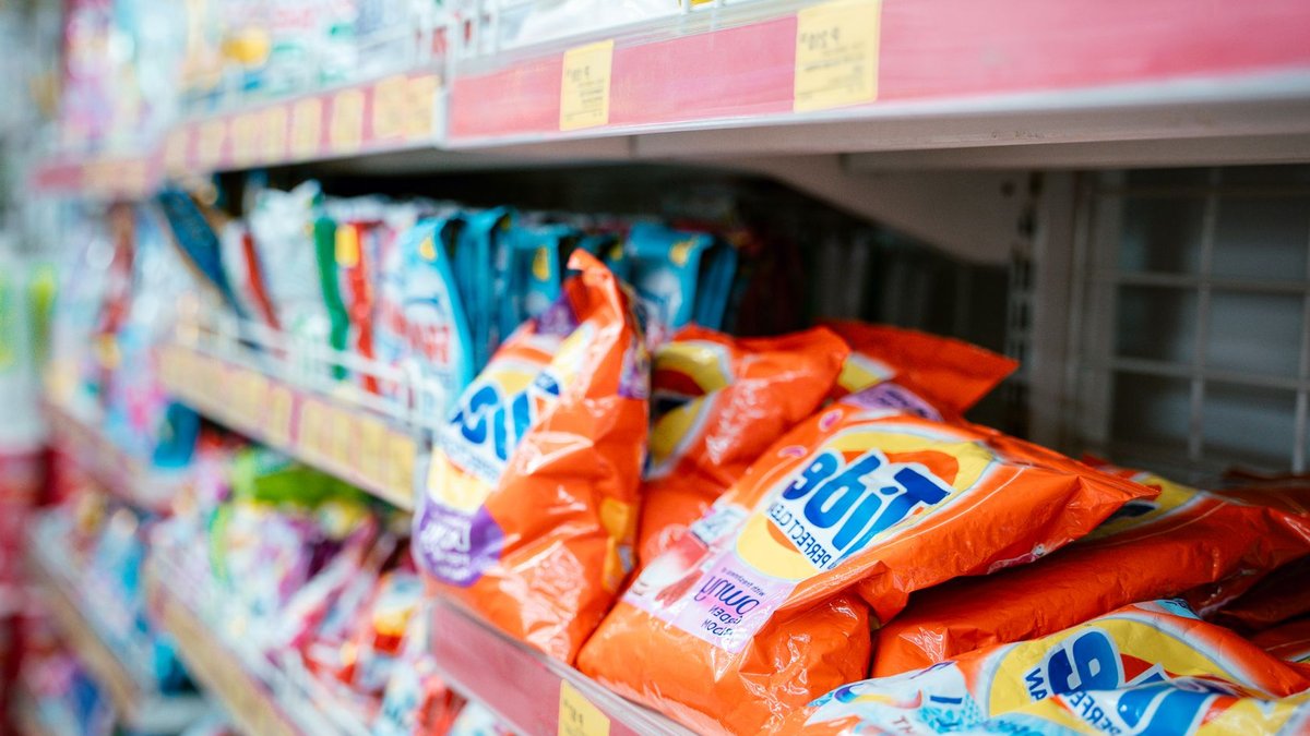 Vibrant selection of laundry detergents on a supermarket shelf, showcasing brands and variety.