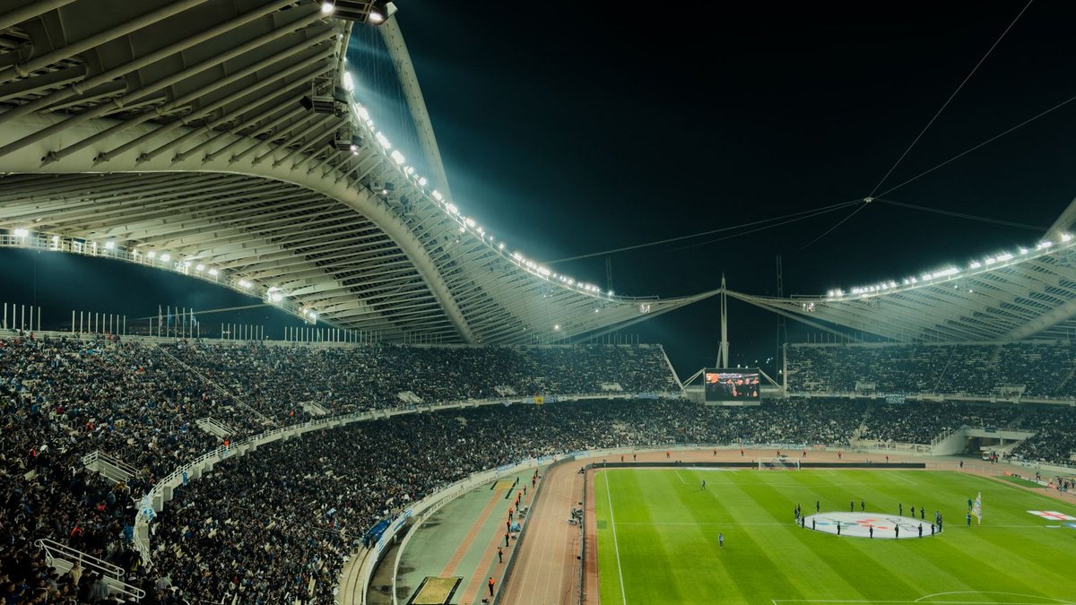 A crowded soccer stadium under bright lights at night, capturing the excitement of a live sports event.