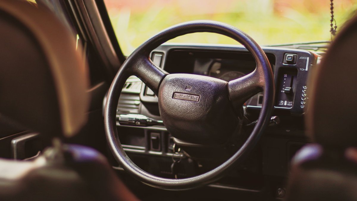 Maruti Suzuki to Launch Electric MPV by 2027 Close-up of the steering wheel in a classic Maruti 800, highlighting vintage automotive design details.