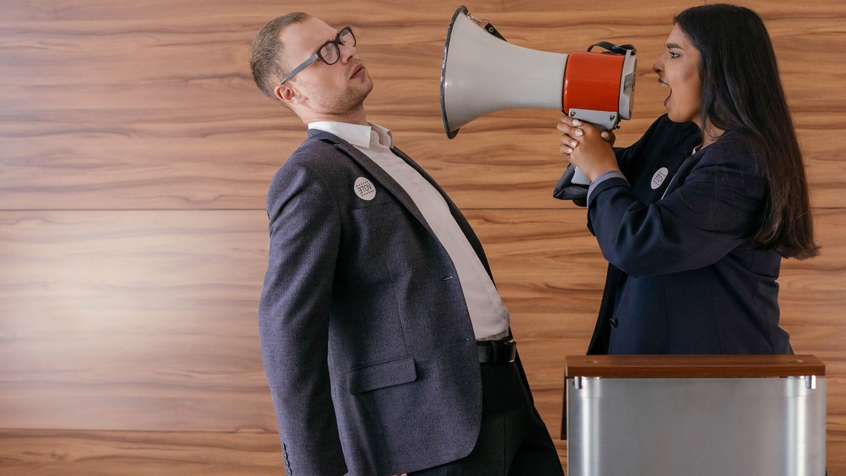 French left wing primary debate takes place Dynamic image of two politicians arguing; one shouts into a megaphone in a heated debate.
