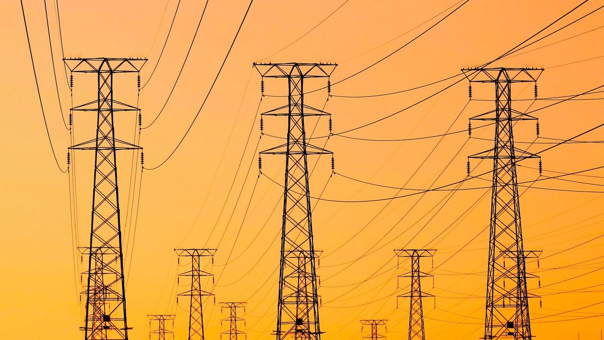 ADB to fund Bangladesh's solar expansion Silhouetted power lines against a vibrant orange sunset, symbolizing energy and infrastructure.
