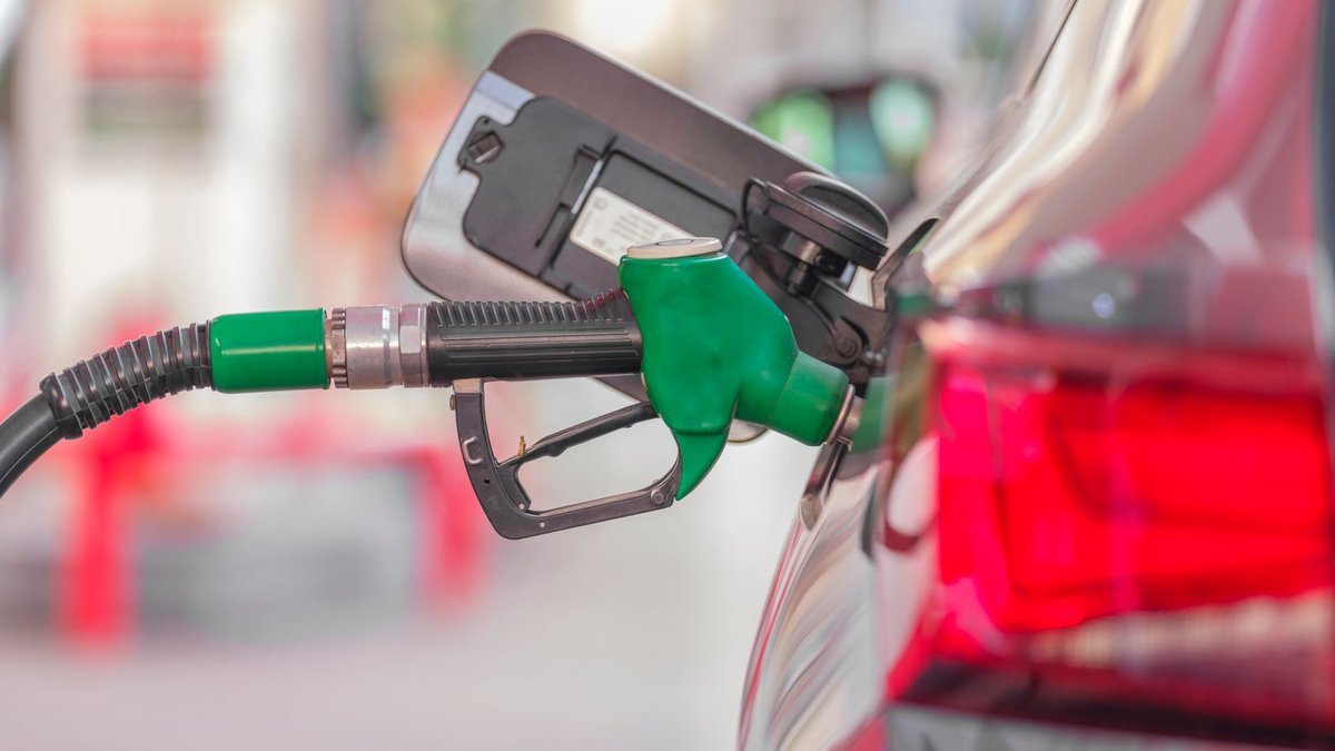 Diesel tax hike raises inflation concerns in Bangladesh A close-up view of a fuel pump nozzle inserted into a car's tank at a gas station.