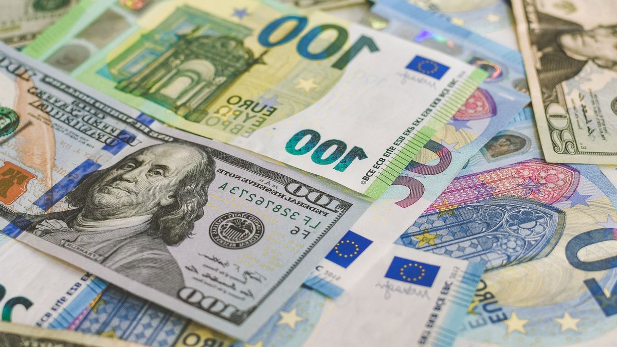 A detailed image of Euro and US dollar banknotes scattered, symbolizing global currency exchange.