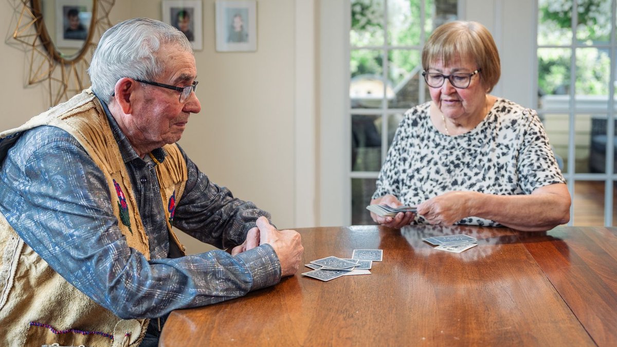 Eynod Switches to Card Payments Cuts Delays Senior couple playing cards at home, enjoying leisure time together in a cozy setting.