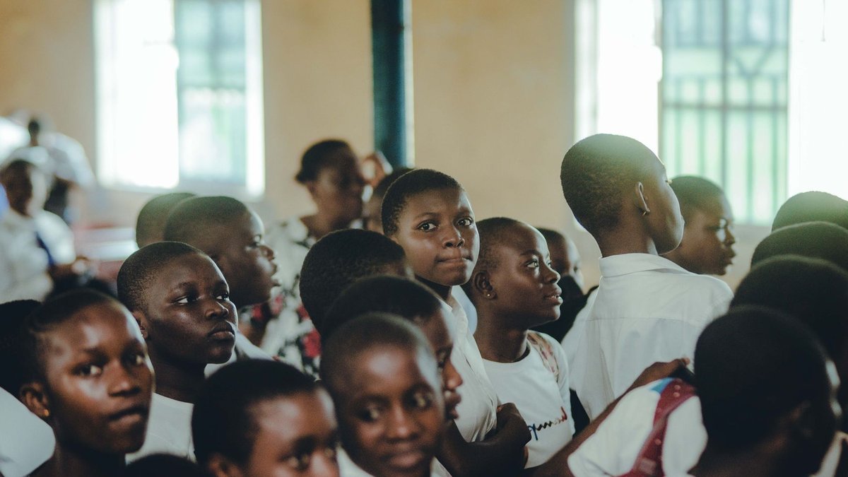 Bullying, Anxiety Drive School Absences in Bristol A diverse group of students attentively participating in an indoor school assembly.