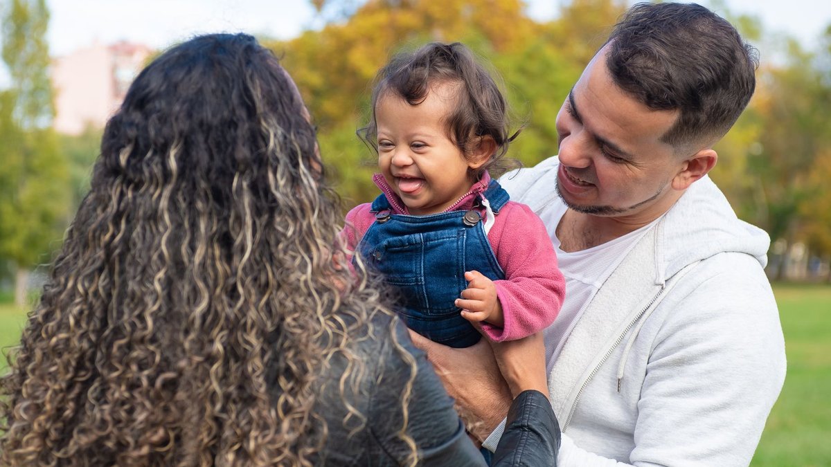Young parents face growing barriers to stable jobs Smiling parents with a joyful child enjoying a day at the park, embracing family bonds.