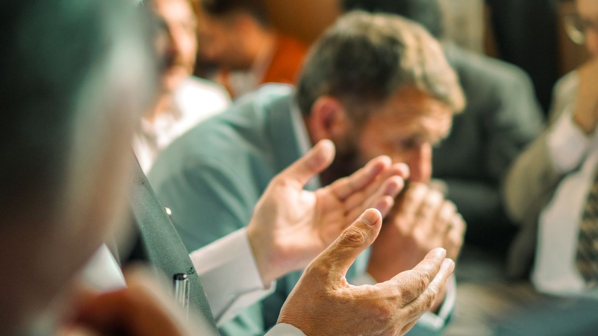 A group of people in a prayer meeting with focused expressions, highlighting spirituality and devotion.