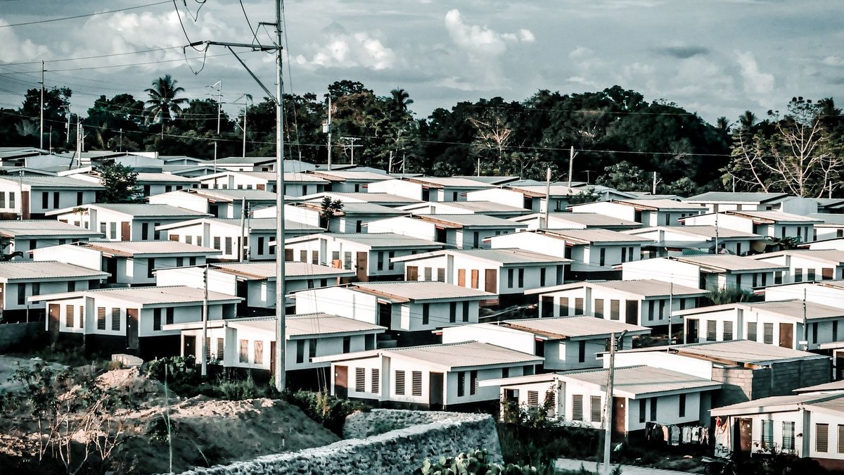 Dallas nursing home repurposed into affordable housing with social services Aerial shot of a modern suburban housing area with identical homes under a cloudy sky.