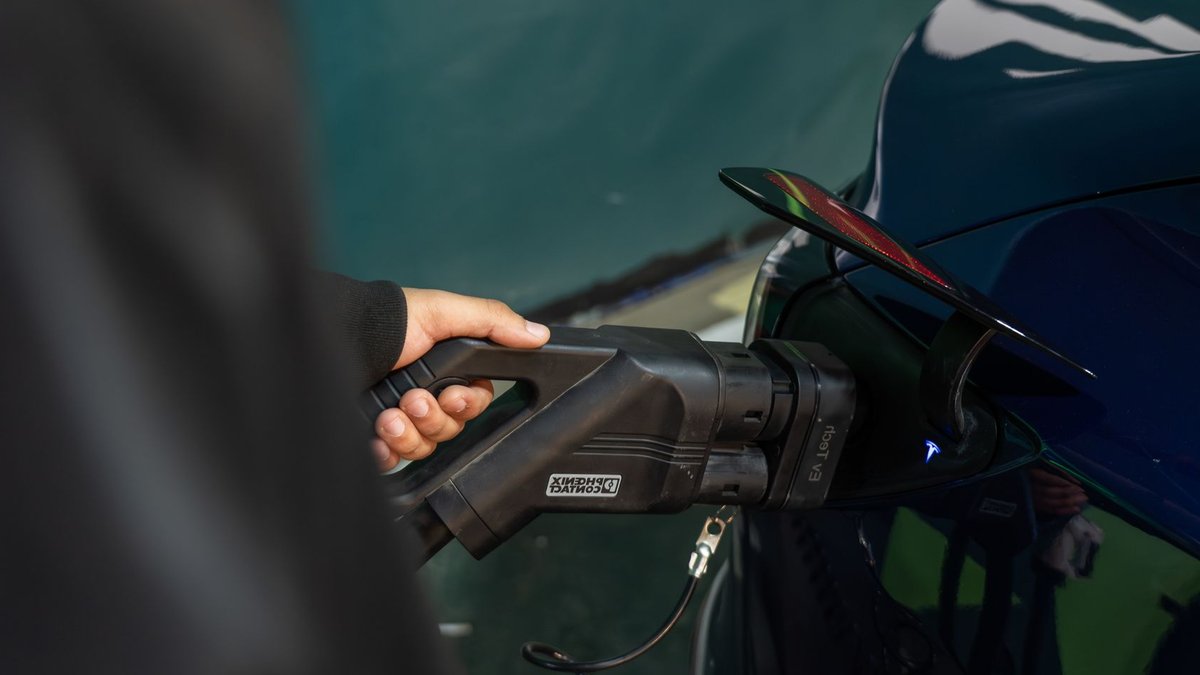 Close-up of an electric vehicle being charged at a station.
