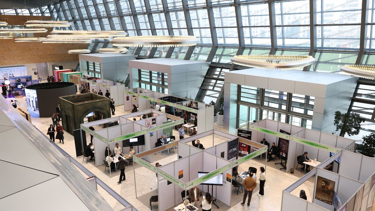 Global food trends on display in Paris A bustling trade show exhibition inside a modern hall with people networking and exploring booths.