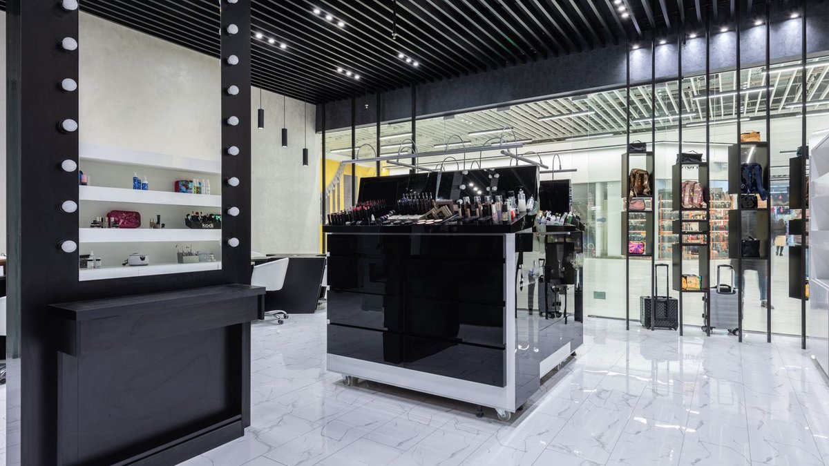 Patrick Ta Beauty appoints new CMO and Creative VP Sleek modern interior of a beauty store with cosmetics and chic decor.