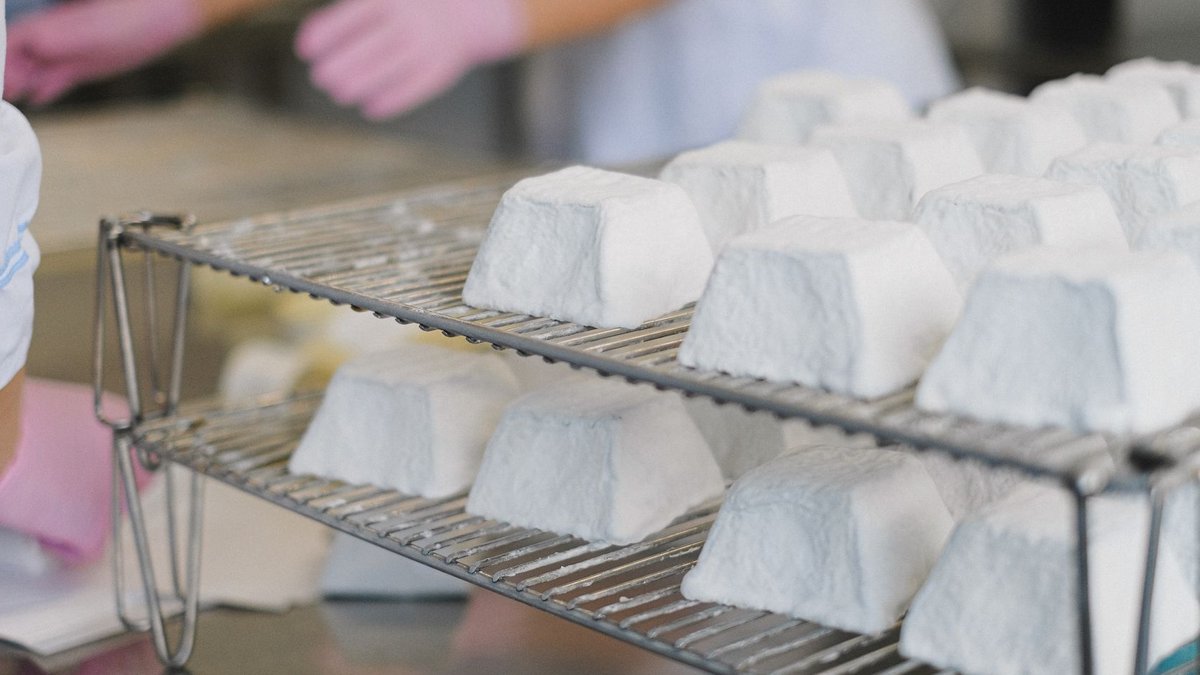 U.S. dairy industry pours $15 billion into expansion Close-up of artisanal cheese wheels on racks in a modern dairy factory.