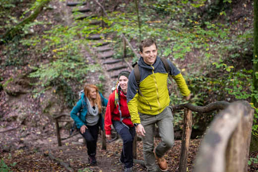 Wanderer durchqueren eine der typischen Klammen auf dem Wanderweg "Rund um Dalem"