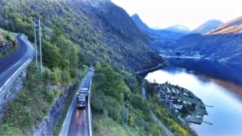 A working truck is paving the road stretch of Geiranger, going through the massive fjords and mountains of Norway.