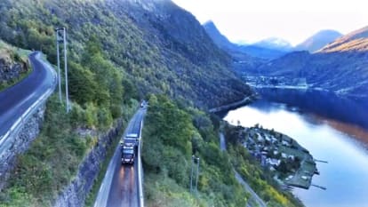 A working truck is paving the road stretch of Geiranger, going through the massive fjords and mountains of Norway.