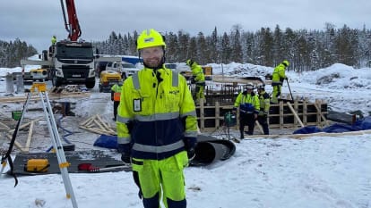 Arbetare jobbar med elförsörjningsjobb på arbetsplats omringad av snö.