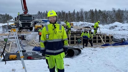 Arbetare jobbar med elförsörjningsjobb på arbetsplats omringad av snö.