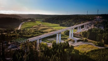 Flygfoto över Hudälvsbron i Rabbalshede, Västra Götaland. Skog och natur breder ut sig åt alla håll.