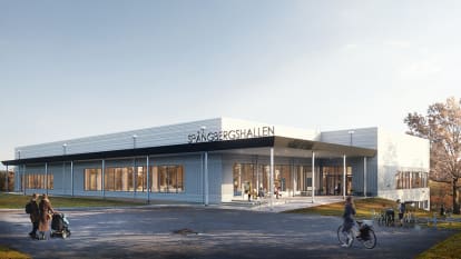 Bild på en skolgård med elever och en grå skolbyggnad.