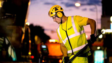 Picture of a worker laying asphalt in the dusk.