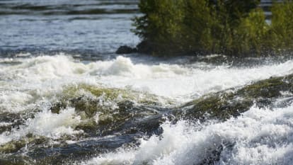 Vatten plaskar våldsamt vid en ström.