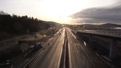 Två fordonsvägar - en järnväg och en asfaltsväg, båda under utbyggnad och på väg mot horisonten.
