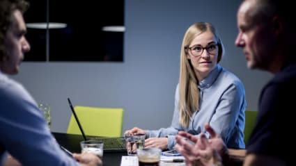 Tre inköpare sitter runt ett bord och diskuterar.