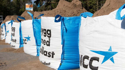 Bild på en lång rad med NCC:s stora säckar fyllda med sand. på säckarna står texten