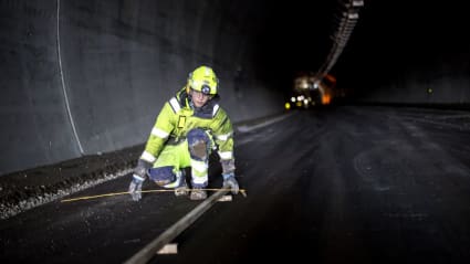 Picture of a worker conducting maintenance work inside a road tunnel.