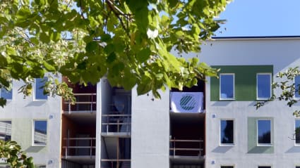 Bild på ett lägenhetshus där en textil med Svanenmärket fladdrar längs med en balkong.