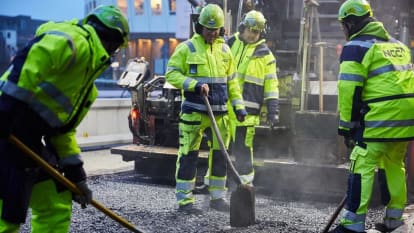 Män som arbetar med asfalt på en väg