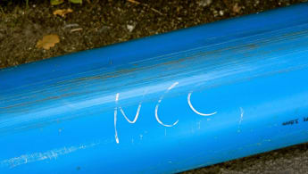 Closeup of a blu water pipe with "NCC" written on it.