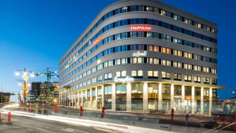 Huset Torsplan i Stockholm. Byggnaden och kringgärdande trafik lyser upp i kvällsmörkret.