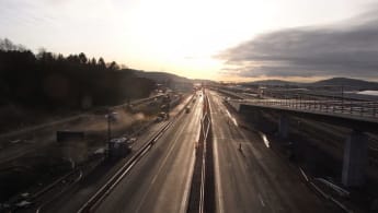 Två fordonsvägar - en järnväg och en asfaltsväg, båda under utbyggnad och på väg mot horisonten.