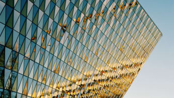 A picture of the auditorium of Karolinska Institute, with the glass facade reflecting other buildings off-camera.