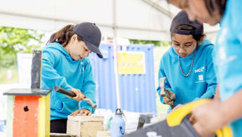 A group of children constructing their own objects outdoors.