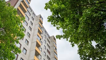 A ground view of an apartment complex with a grey and orange facade.