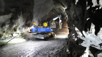 A machine drills the cave wall inside a future rail tunnel.