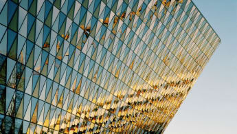 A picture of the auditorium of Karolinska Institute, with the glass facade reflecting other buildings off-camera.