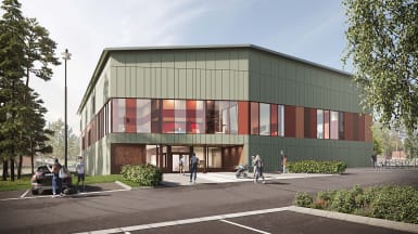 Bild på Hertsö Badhus i Luleå, grönt hus omringat av träd.