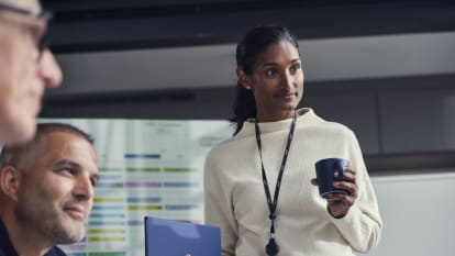 Three NCC employees in an office discussing a project plan.