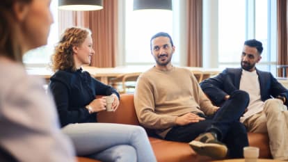 Four NCC employees sitting in a sofa talking.