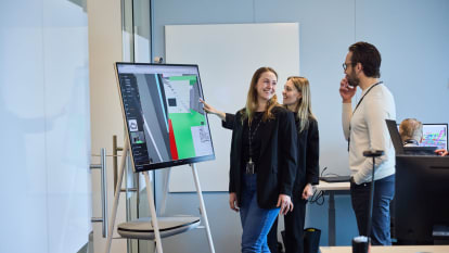 I ett mörktlagt rum inspekterar flera personer olika 3D-modeller som projiceras mot väggen.