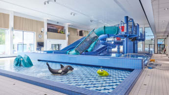 Simanläggning med barnpool och rutschkana.