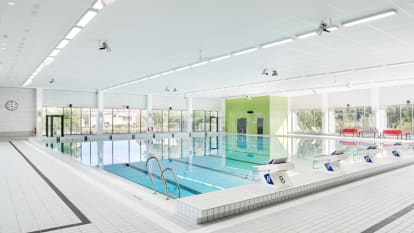 Bild på bassängen i Sjöbos nya simanläggning, med omväxlande grönt kakel och stora fönster som vägg.