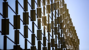 Detailed view of the facade of Royal College of Music in Stockholm, with metal pieces reflected on glass.