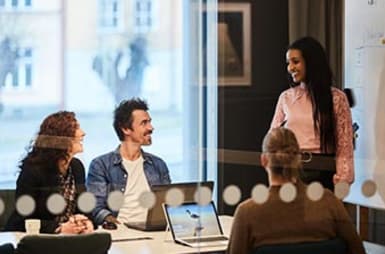 Four people in a meeting room.